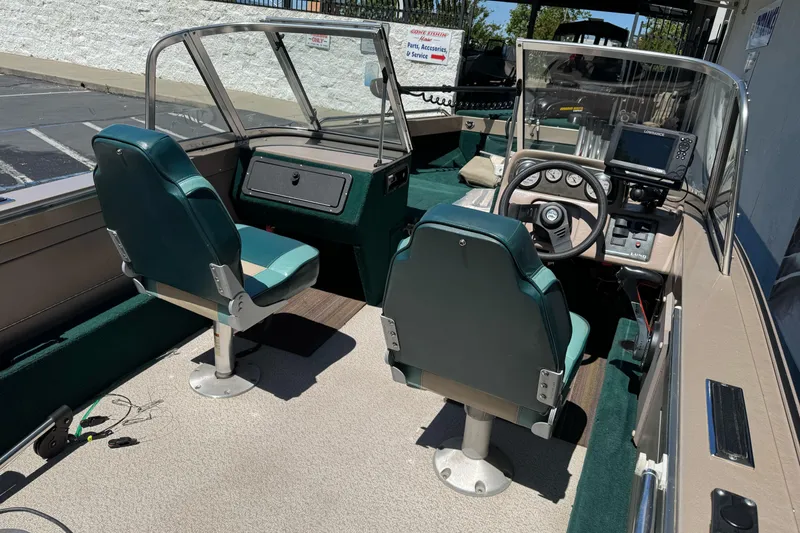 Slide: The Image of 2000 Lund 1600 Pro Sport boat interior with green seats and steering console. - 15