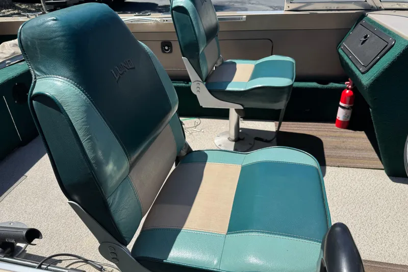 Slide: The Image of Interior of 2000 Lund 1600 Pro Sport boat with teal seats and fire extinguisher. - 17