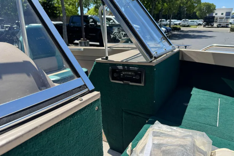 Slide: The Image of 2000 Lund 1600 Pro Sport boat interior with green upholstery and windshield detail. - 20