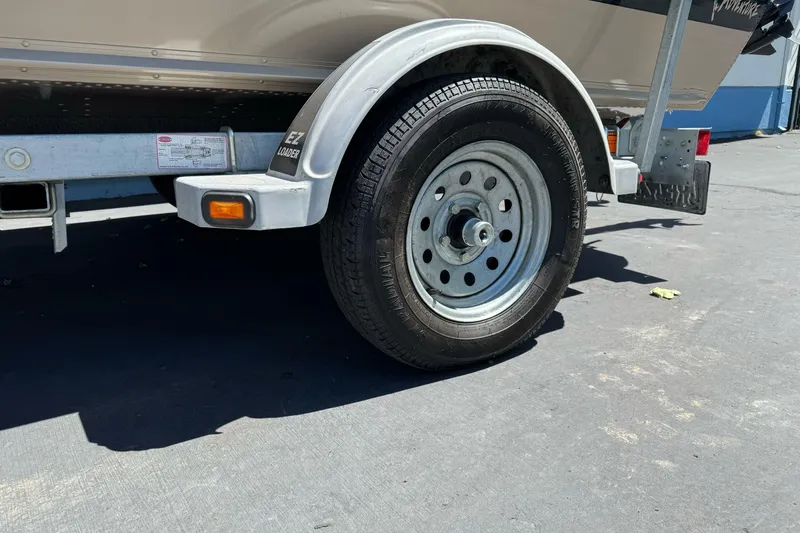 Slide: The Image of Trailer wheel of a 2000 Lund 1600 Pro Sport boat on pavement. - 3