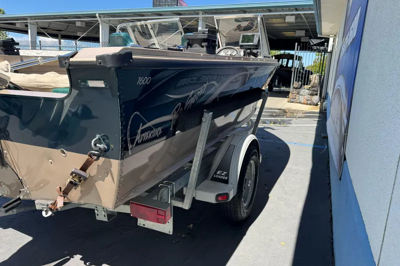 Slide: The Image of 2000 Lund 1600 Pro Sport boat on trailer, parked outdoors near a building. - 6