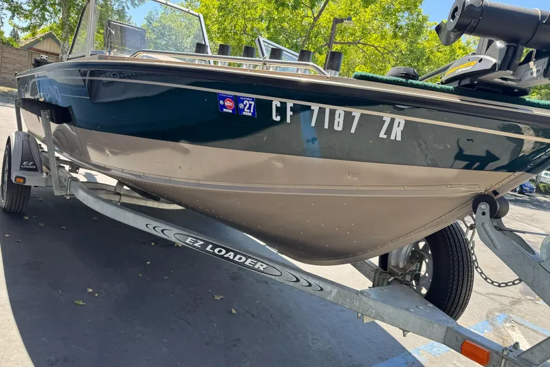 Slide: The Image of 2000 Lund 1600 Pro Sport boat on EZ Loader trailer in sunny outdoor setting. - 7