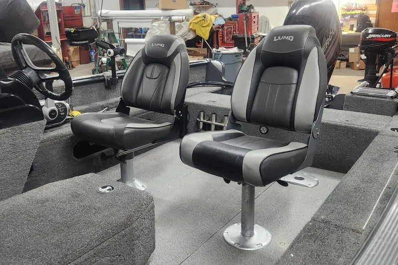 Slide: The Image of 2018 Lund 1650 Rebel XS Tiller boat interior with two black and gray seats. - 10