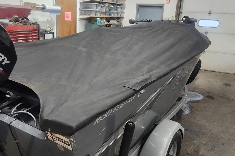 Slide: The Image of 2018 Lund 1650 Rebel XS Tiller boat covered in a garage setting. - 15