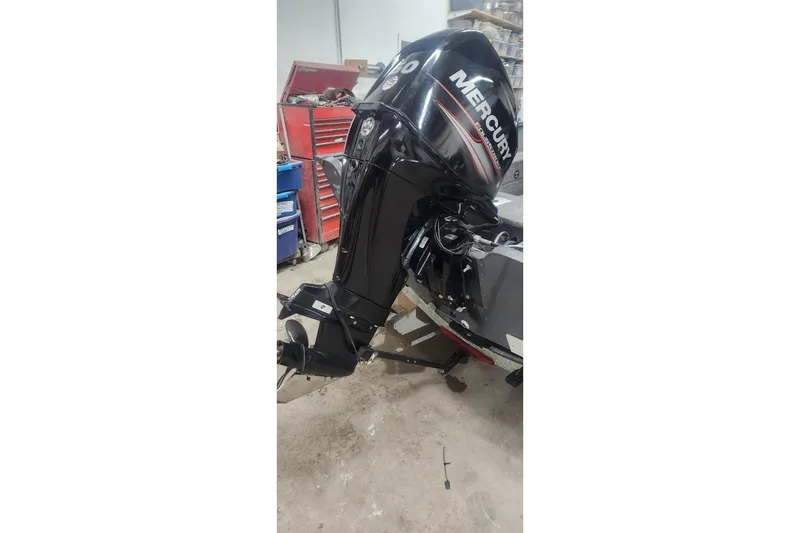 Slide: The Image of 2018 Lund 1650 Rebel XS Tiller with Mercury outboard motor in workshop setting. - 16