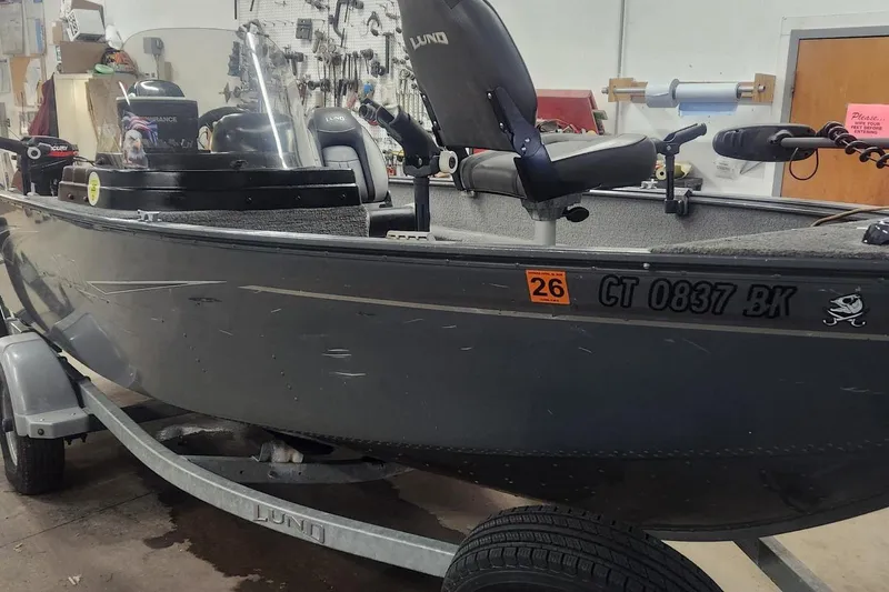 Slide: The Image of 2018 Lund 1650 Rebel XS Tiller boat on trailer in garage setting. - 7