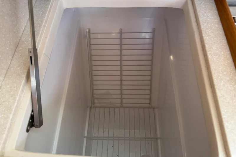 Slide: The Image of Empty refrigerator compartment in a 2023 Catalina 425 yacht. - 21