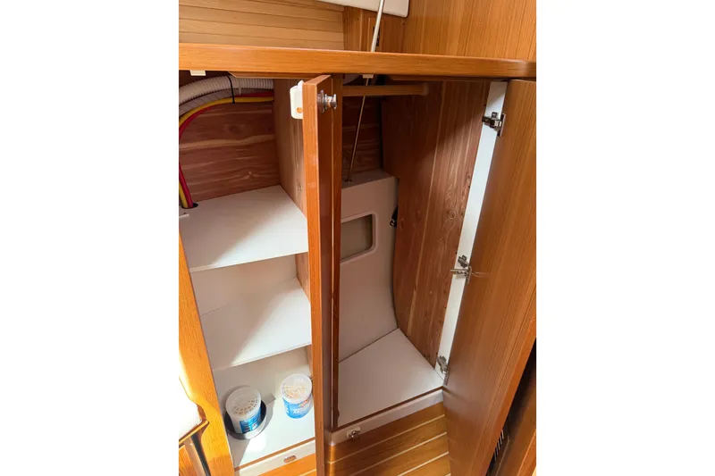 Slide: The Image of Wooden cabinet interior on a 2023 Catalina 425 yacht, featuring shelves and storage space. - 36