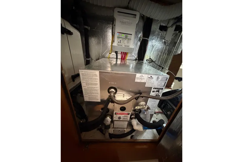 Slide: The Image of Engine compartment of a 2023 Catalina 425 sailboat, featuring mechanical components and wiring. - 38