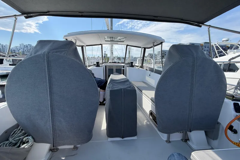 Slide: The Image of 2023 Catalina 425 yacht cockpit with covered seating, docked at a marina under a clear sky. - 5