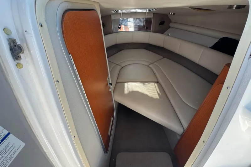 Slide: The Image of Interior cabin of 2005 Chaparral 255 SSi boat with beige seating and wooden door. - 26