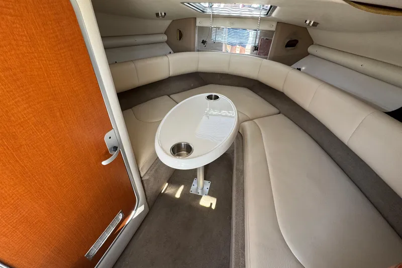 Slide: The Image of Interior of a 2005 Chaparral 255 SSi boat with beige seating and a central table. - 28