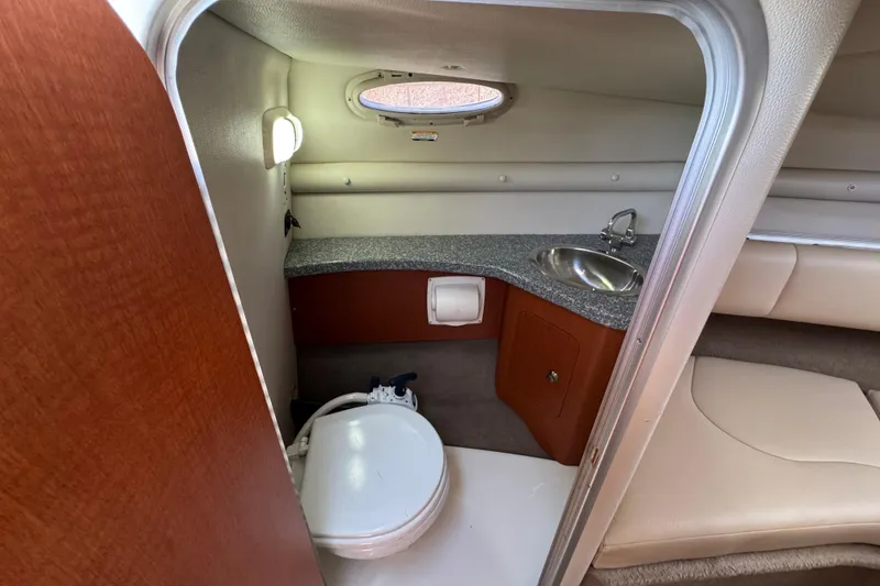Slide: The Image of 2005 Chaparral 255 SSi boat interior with compact bathroom and sink. - 30