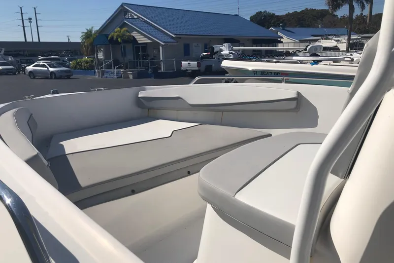 Slide: The Image of 2022 Key Largo 1800 Center Console boat interior with seating, parked at a marina. - 9