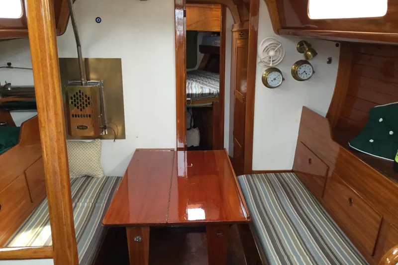 Slide: The Image of Interior of a 1969 Ohlson 38 sailboat with polished wood and striped seating. - 2