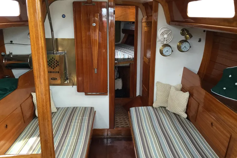 Slide: The Image of Interior of a 1969 Ohlson 38 sailboat with wooden furnishings and striped cushions. - 3