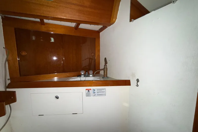 Slide: The Image of Wooden interior of a 1969 Ohlson 38 sailboat with a compact sink area. - 8