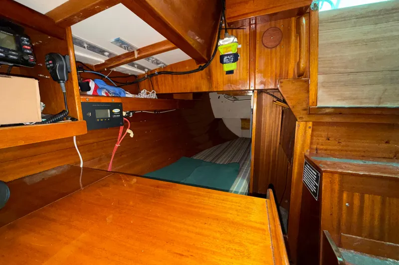 Slide: The Image of Interior of a 1969 Ohlson 38 sailboat with wooden cabinetry and navigation equipment. - 9