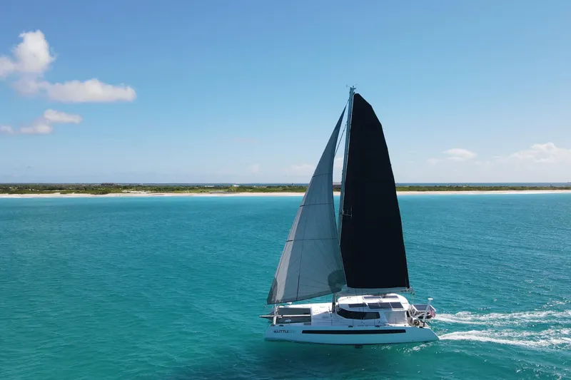 Slide: The Image of Sailing catamaran Balance 526 gliding on turquoise waters under clear blue skies, 2021 model. - 2