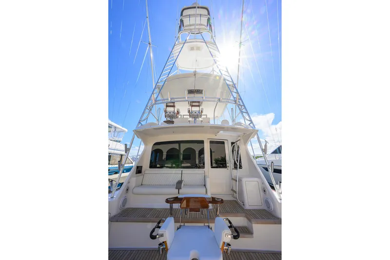 Slide: The Image of 2007 Viking 56 Convertible yacht with spacious deck and tower under bright sun. - 11