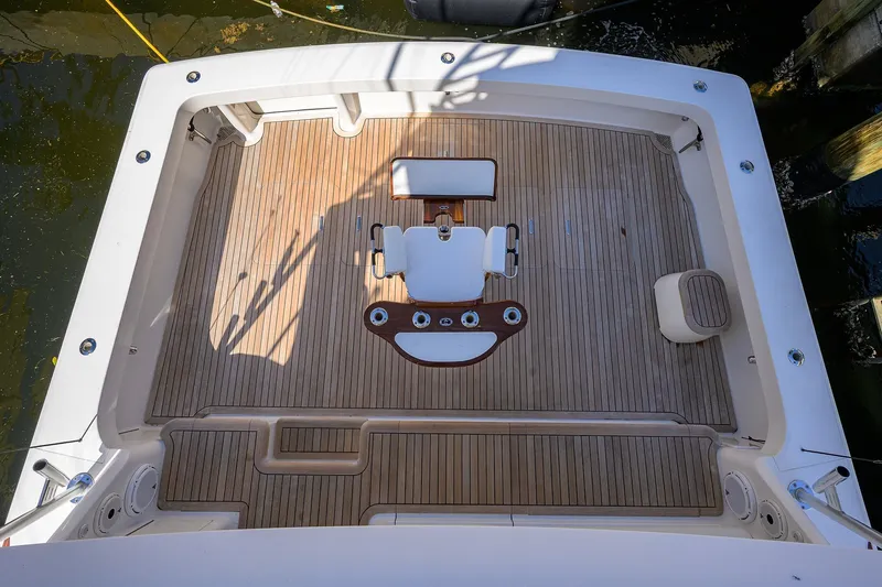 Slide: The Image of 2007 Viking 56 Convertible yacht deck with wooden flooring and seating arrangement. - 12