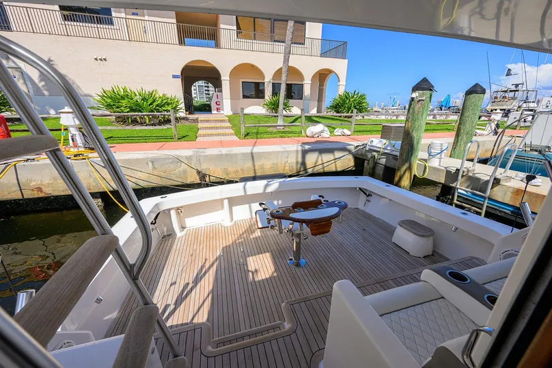 Slide: The Image of 2007 Viking 56 Convertible yacht docked, featuring spacious deck and marina view. - 18