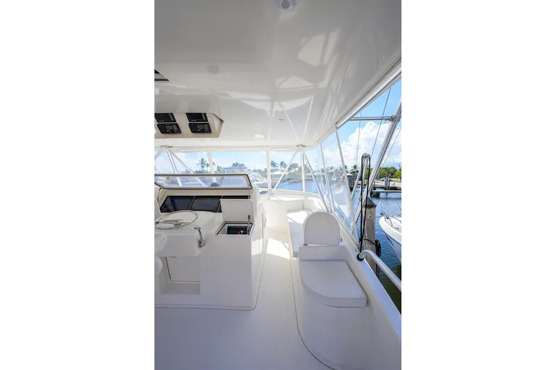 Slide: The Image of 2007 Viking 56 Convertible yacht interior with helm station and seating, docked at marina. - 19