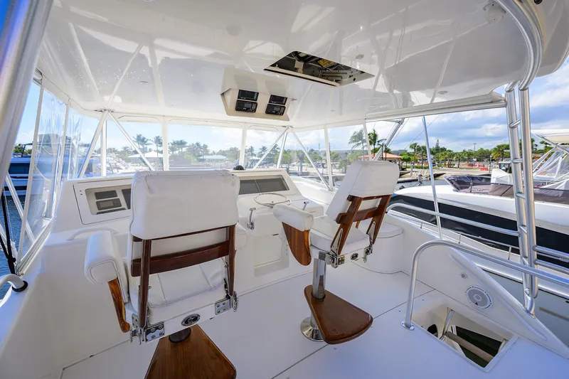 Slide: The Image of 2007 Viking 56 Convertible yacht helm with white seating and panoramic marina view. - 20