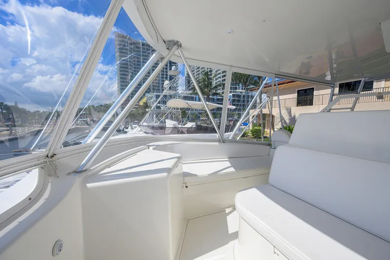 Slide: The Image of 2007 Viking 56 Convertible yacht interior with white seating and marina view. - 27