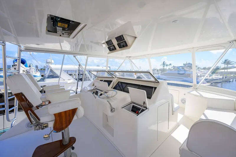 Slide: The Image of 2007 Viking 56 Convertible yacht helm with white seating and marina view. - 29