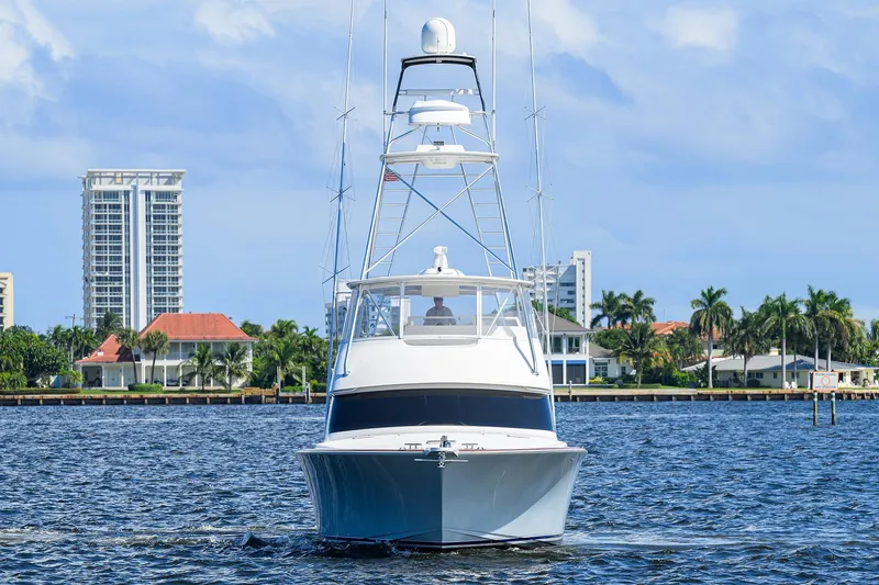 Slide: The Image of 2007 Viking 56 Convertible yacht cruising on a sunny day near waterfront homes. - 3