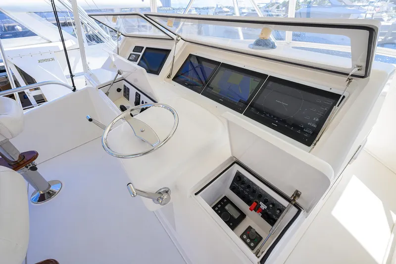 Slide: The Image of Control panel of a 2007 Viking 56 Convertible yacht with navigation screens and steering wheel. - 30