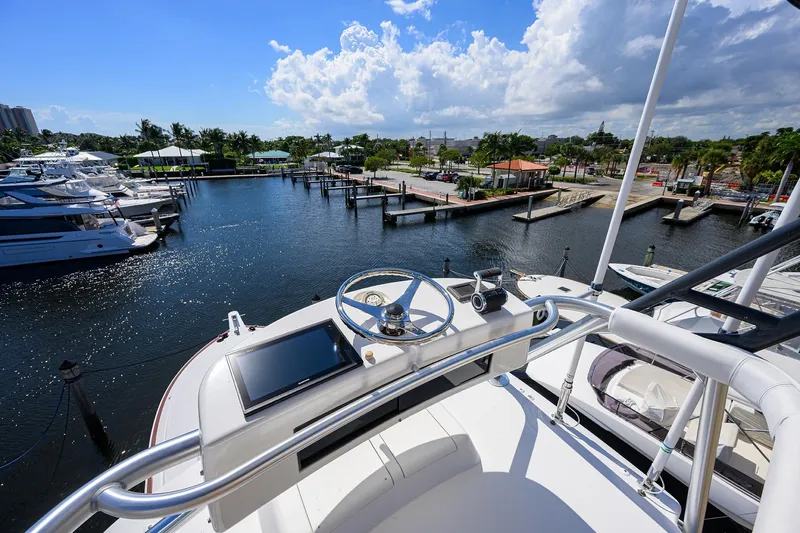 Slide: The Image of 2007 Viking 56 Convertible yacht helm overlooking marina with clear skies and calm waters. - 31