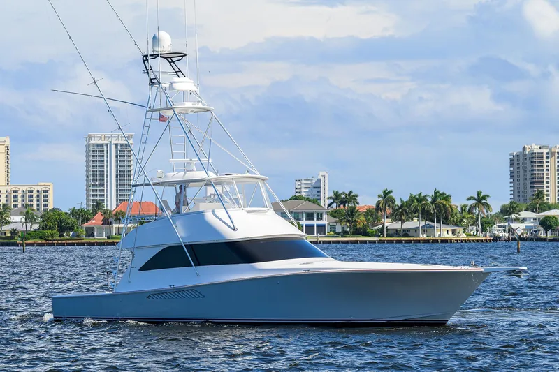 Slide: The Image of 2007 Viking 56 Convertible yacht cruising on a scenic waterfront with city skyline. - 5