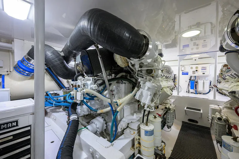 Slide: The Image of Engine room of a 2007 Viking 56 Convertible yacht, showcasing complex machinery and piping. - 77