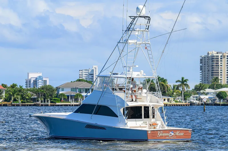 Slide: The Image of 2007 Viking 56 Convertible yacht cruising near waterfront homes and palm trees. - 8