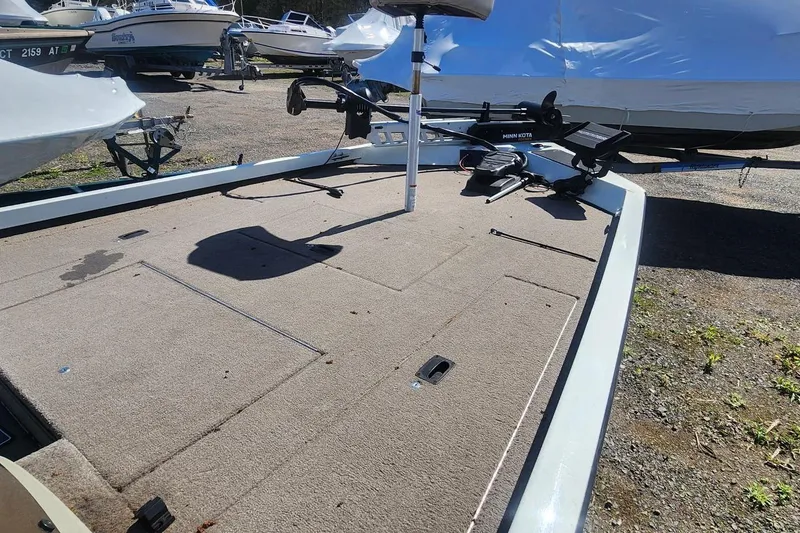 Slide: The Image of 2008 Triton VT 19 boat deck with Minn Kota trolling motor, parked among other boats. - 3