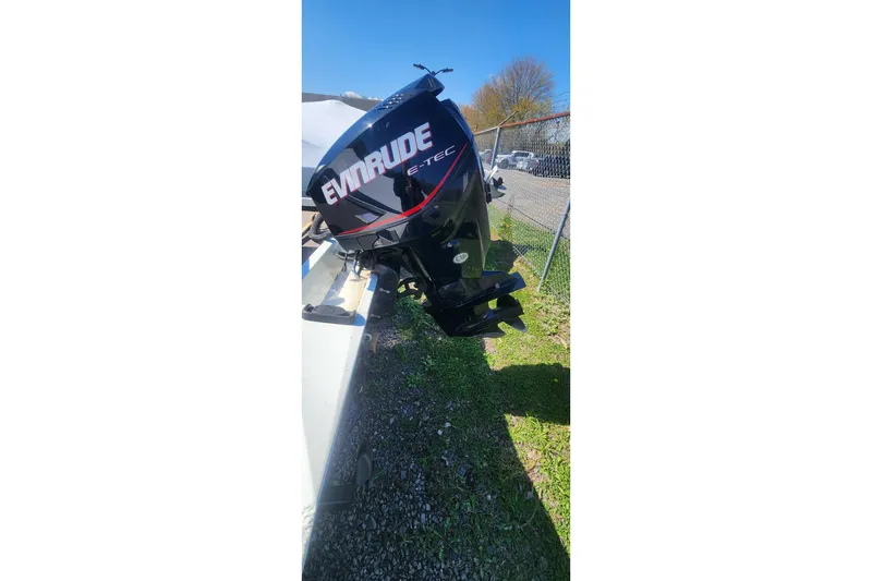 Slide: The Image of 2008 Triton VT 19 boat with Evinrude E-TEC outboard motor, parked outdoors. - 7