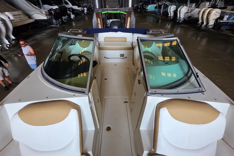 Slide: The Image of 2012 SouthWind 2400 SD boat interior in storage facility, showcasing seating and windshield. - 17
