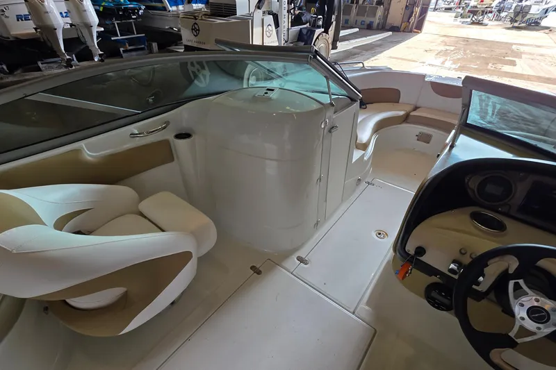 Slide: The Image of Interior of a 2012 SouthWind 2400 SD boat, featuring seating and steering area. - 27