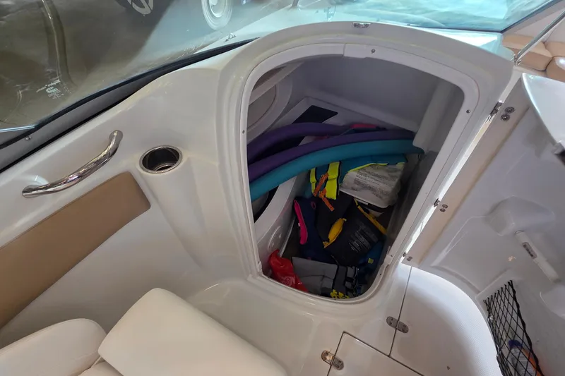 Slide: The Image of Storage compartment in a 2012 SouthWind 2400 SD boat, containing pool noodles and life jackets. - 30