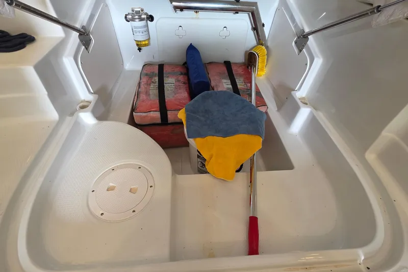 Slide: The Image of Storage compartment of a 2012 SouthWind 2400 SD boat with cleaning supplies and equipment. - 33