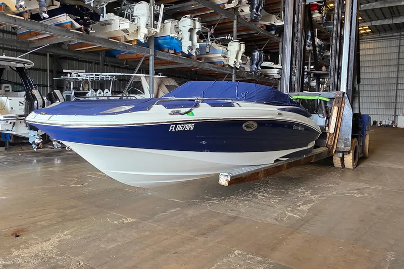 Slide: The Image of 2012 SouthWind 2400 SD boat in storage facility, blue and white hull. - 5