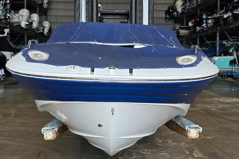 Slide: The Image of 2012 SouthWind 2400 SD boat with blue cover in storage facility. - 9