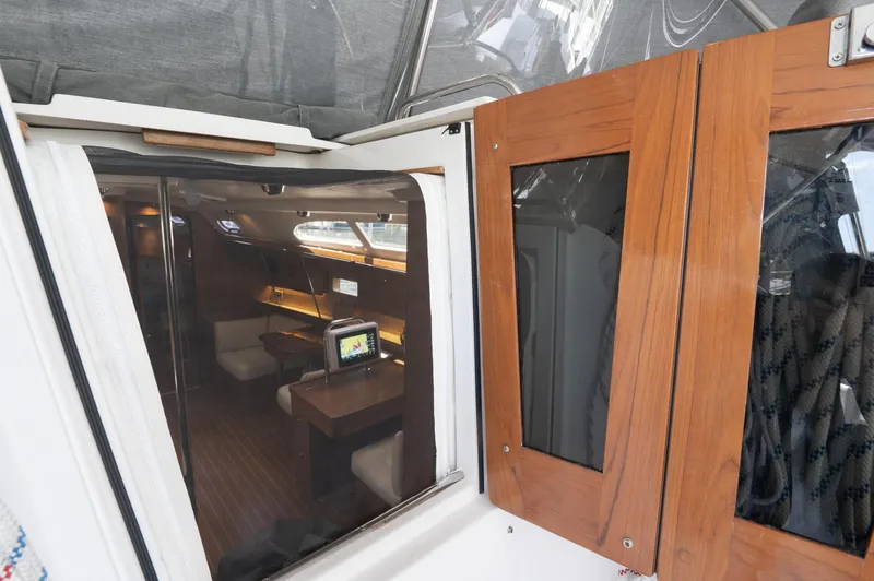 Slide: The Image of 2024 Catalina 445 yacht interior view through wooden doors, showcasing modern cabin design. - 21
