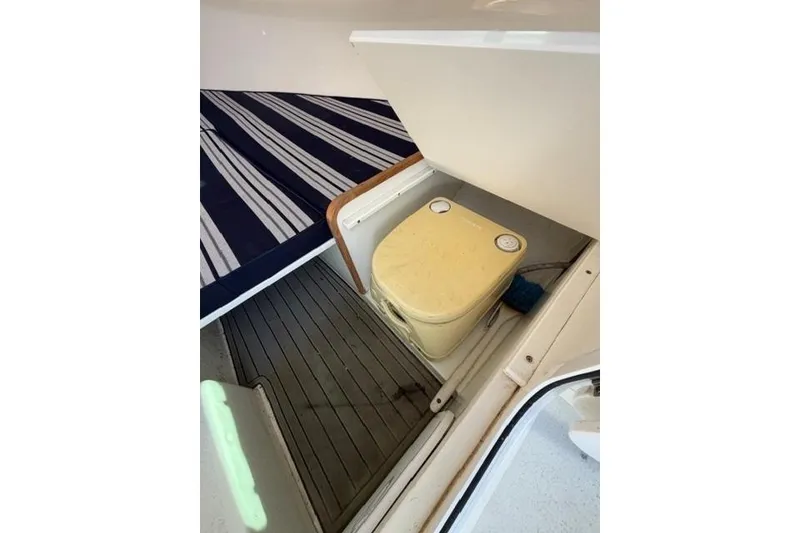 Slide: The Image of Interior of 2020 Eastern 248 Explorer boat with portable toilet and striped cushion. - 6