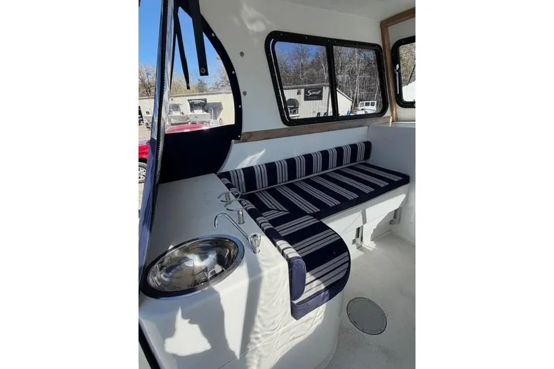Slide: The Image of Interior of 2020 Eastern 248 Explorer boat with striped seating and sink. - 8