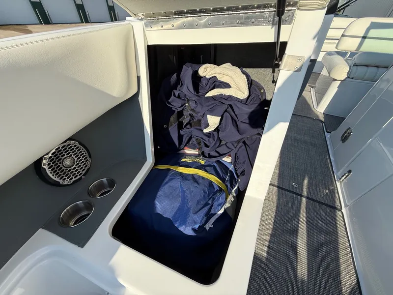 Slide: The Image of Storage compartment in 2015 Cobalt R7 boat with clothes and bag. - 16