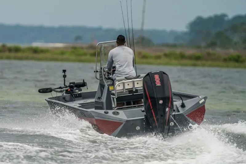 Slide: The Image of 2026 Excel 220 Bay Pro Elite boat navigating through water with a person steering. - 4