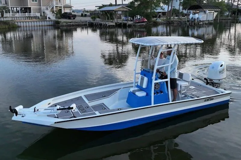 Slide: The Image of 2026 Excel 220 Bay Pro Elite boat on calm water, featuring a sleek blue and white design. - 5